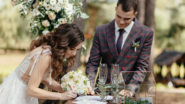 Couple sign marriage documents