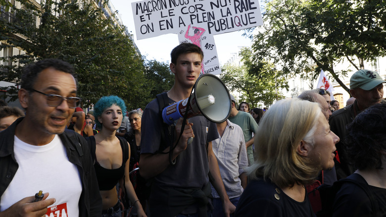 A man with a megaphone among a crowd of protesters during the September 18 demonstration in Paris, France