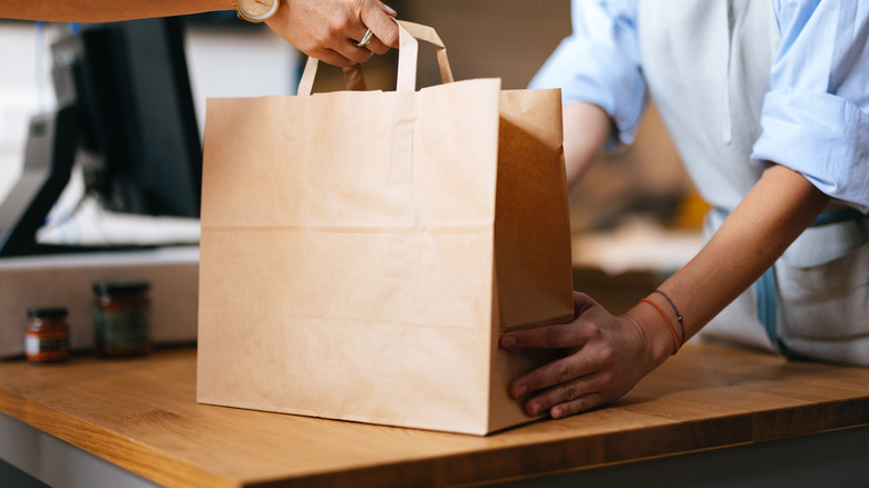 Person grabbing a grocery bag