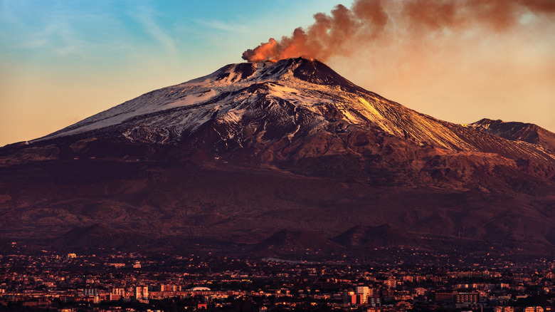 Catania cityscape with smoke rising out of Mount Etna