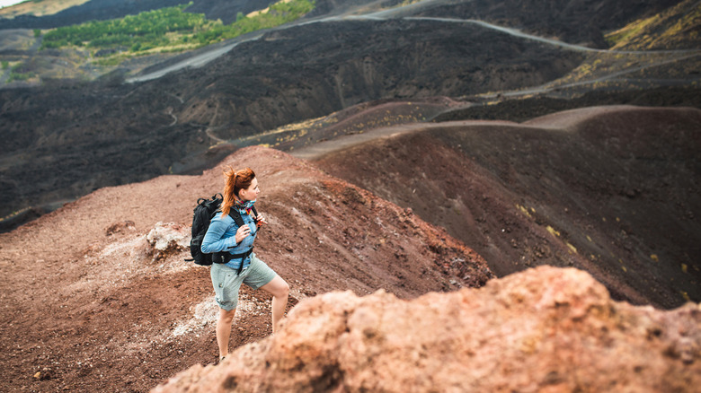 Woman stares into the distance while hiking up Mount Etna