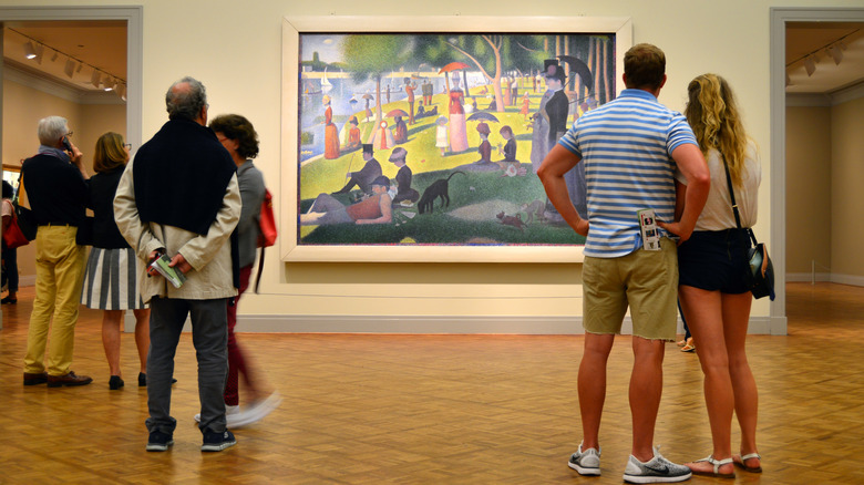 Visitors looking at a George Seurat painting in the Art Institute of Chicago