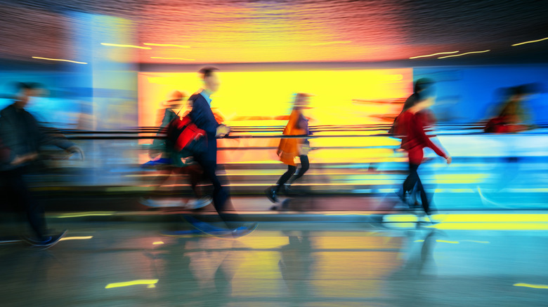 People blurred in motion walking through airport terminal