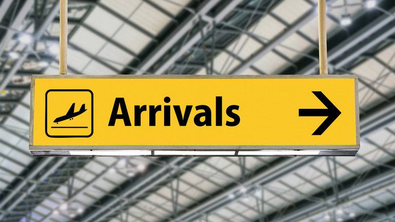 Yellow arrivals sign at an airport