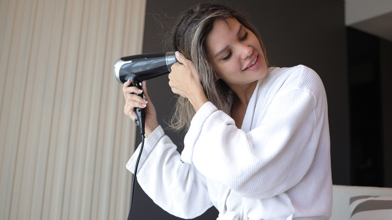 Person using a hair dryer at a hotel