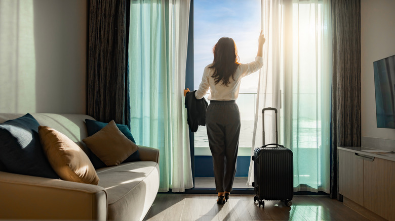 Woman looking out of a hotel room's balcony