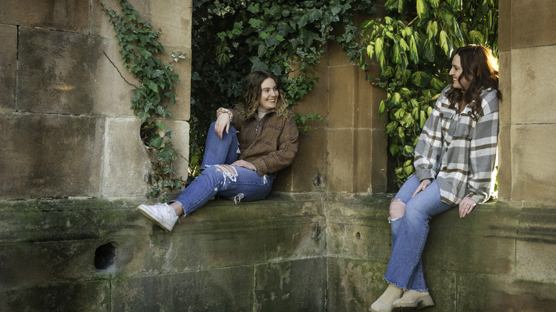 Two friends talking and sitting in a historic university in Glasgow
