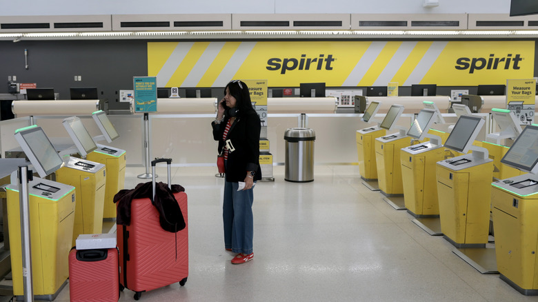 Someone one the phone at the Spirit Airlines check-in area