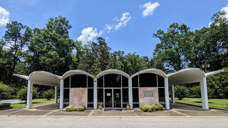 The exterior of the Sylvania Welcome Center with its midcentury modern design surrounded by trees and blue skies