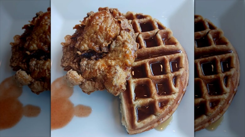 Chicken and waffles with a drizzle of syrup and hot sauce