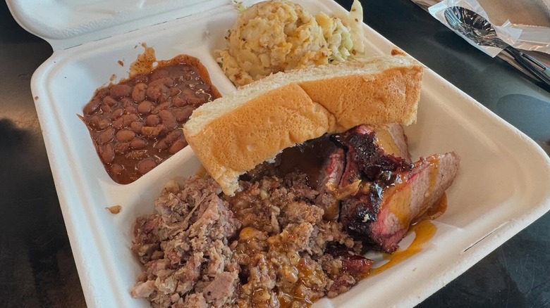 A picture of bread, brisket, potato salad, and beans from Salt Lick's airport location
