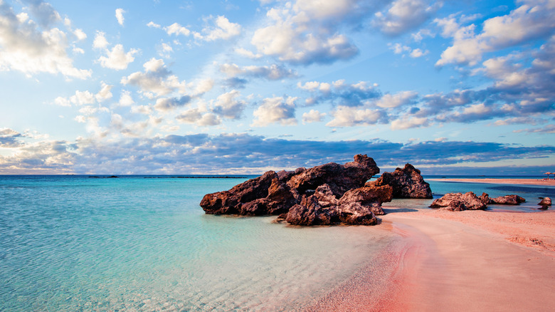 the characteristic pink sand and blue, shallow waters of Elafonissi Beach in Crete, Greece