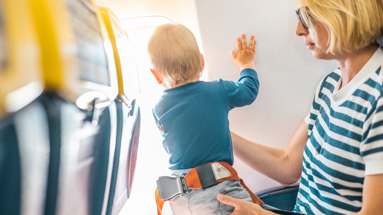 Mother with infant on her lap in economy seats