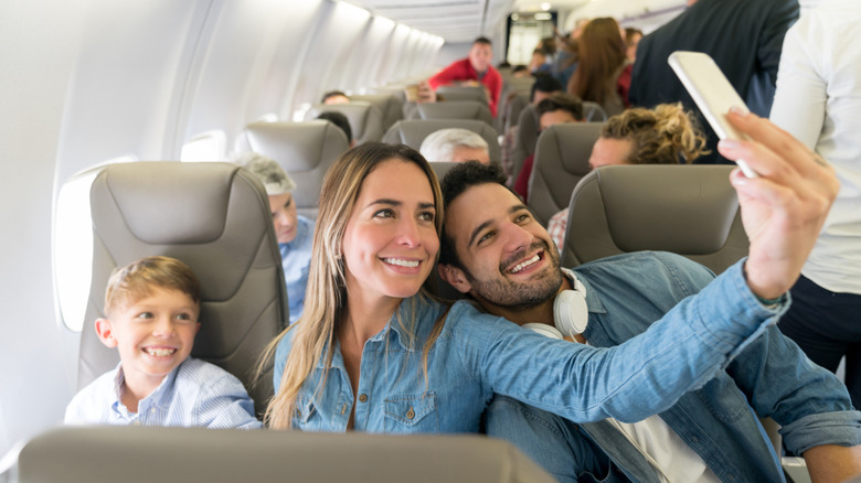 Parents and their son taking a selfie in premium economy seats