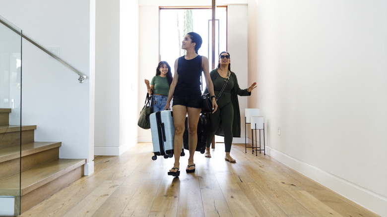 People entering their Airbnb while carrying luggage