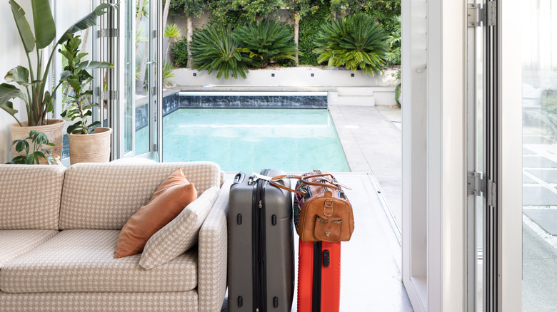 Luggage at an Airbnb with a pool in the background