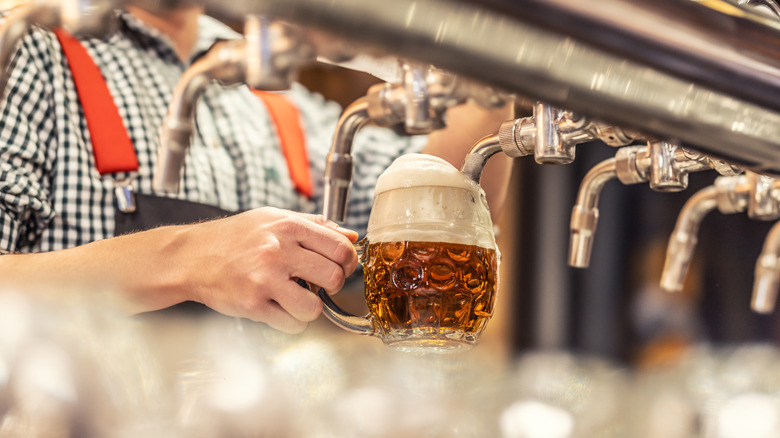 Close-up of person filling a beer stein