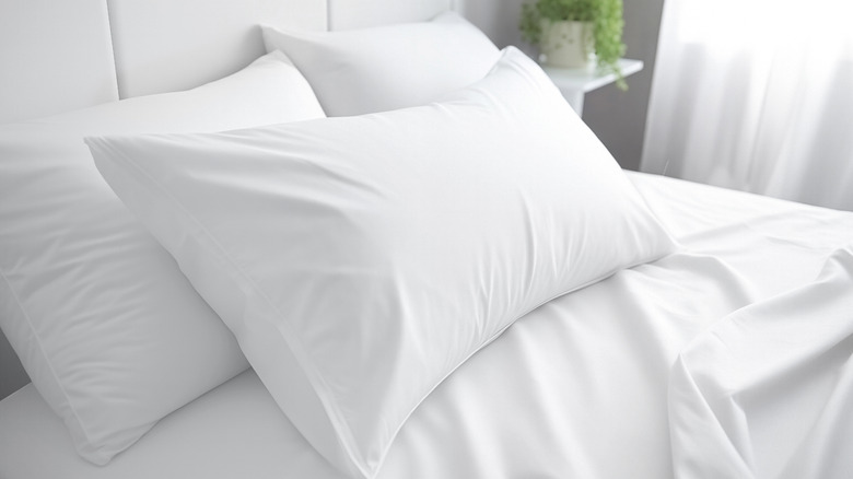 white sheets and pillows on a bed
