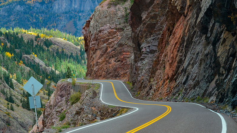 Cliffs descend to Million Dollar Highway (US 550) in Colorado with no guardrails