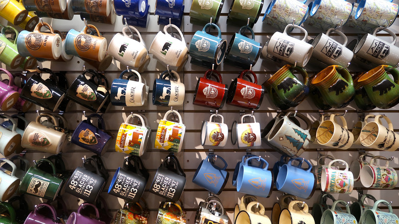 Coffee mugs hang from a wall in a national park gift shop