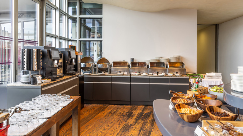 A breakfast buffet is set out in the lobby of a hotel