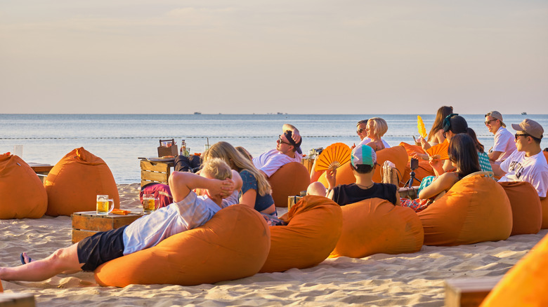 Phú Quốc Tourists lie on beanbags on the sand and watch the sunset