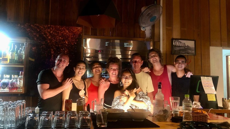 A group of people smiles at the camera in the Cheeky Traveler's English Pub in Phú Quốc
