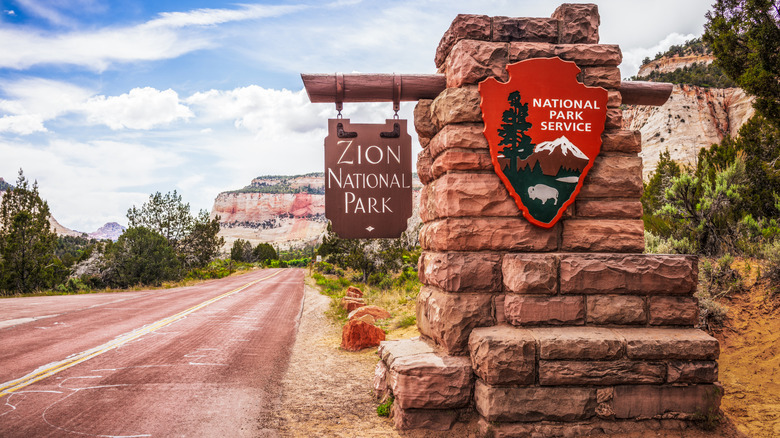 Zion National Park sign with National Park Service on red road