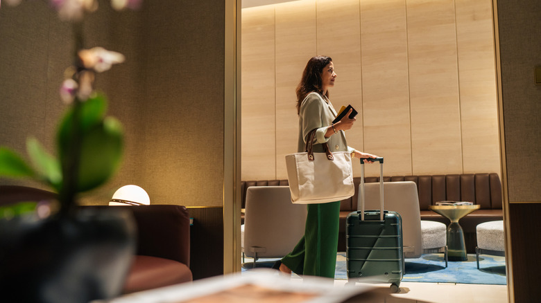 Woman with a suitcase inside an airport lounge