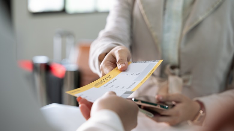 Person handing their boarding pass to airline staff