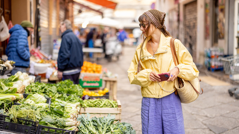 A woman shops at a street market in Palermo, Sicily