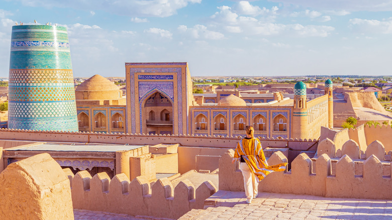 Woman dressed in yellow overlooking town of Khiva, Uzbekistan