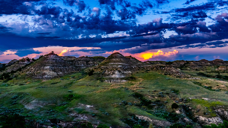 Dramatic sunset with rolling clouds behind the rock formations of Badlands of North Dakota