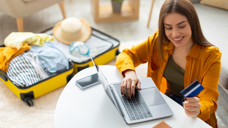 A young woman pays for a vacation online