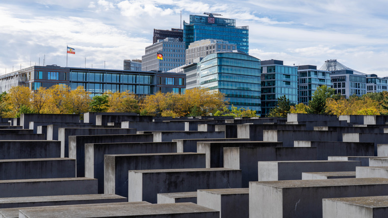 The field of stelae at the Memorial to the Murdered Jews of Europe with modern buildings visible in the background.