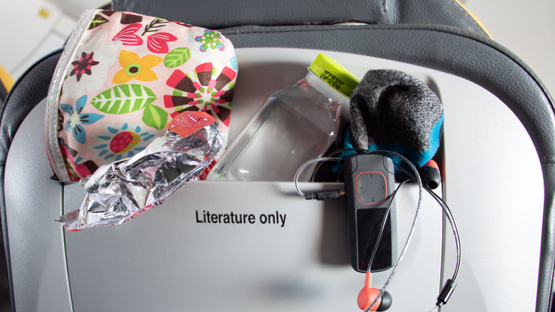 An airplane pocket stuffed with items