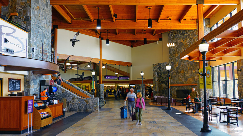 A terminal at Bozeman Yellowstone International Airport with wood-beam ceilings, a stone fireplace, and no crowds