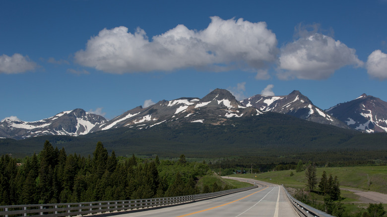 Highway 2 leading to snow-capped mountains in Glacier National Park