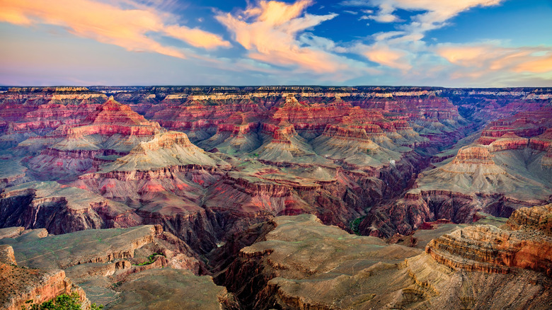 A view of the Grand Canyon showing rock layers from above bright against a blue cloudy sky