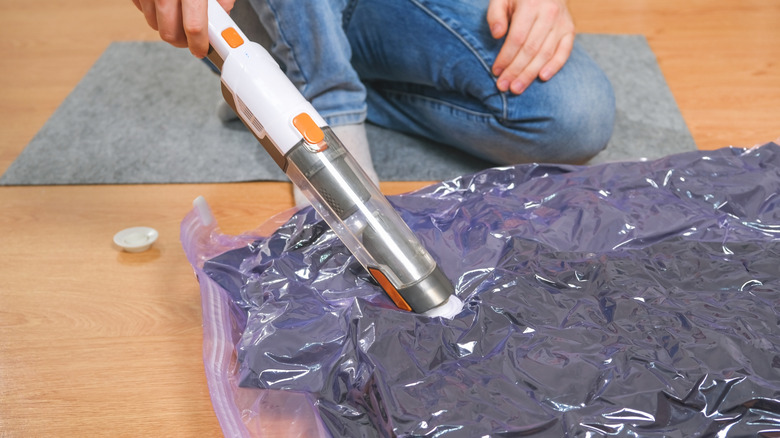 Person using a vacuum cleaner to remove air from bag