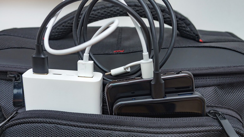 Multiple smartphones charging in the pocket of a suitcase