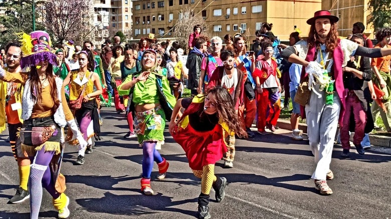 People in the street during a Carnival parade in Scampia