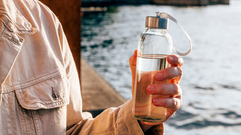 Person holding a refillable water bottle
