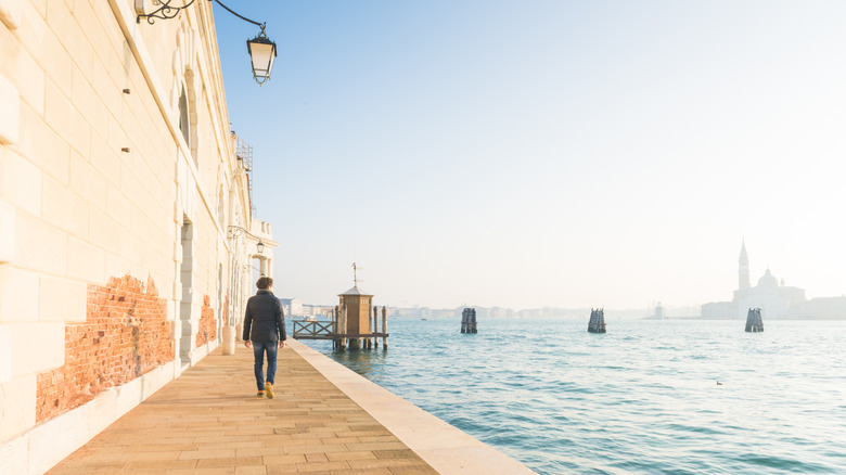 A man enjoying a stroll by the water in Dorsoduro, Venice