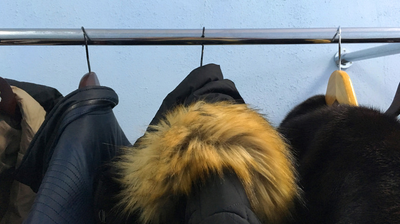 Multiple coats hanging on metal bar