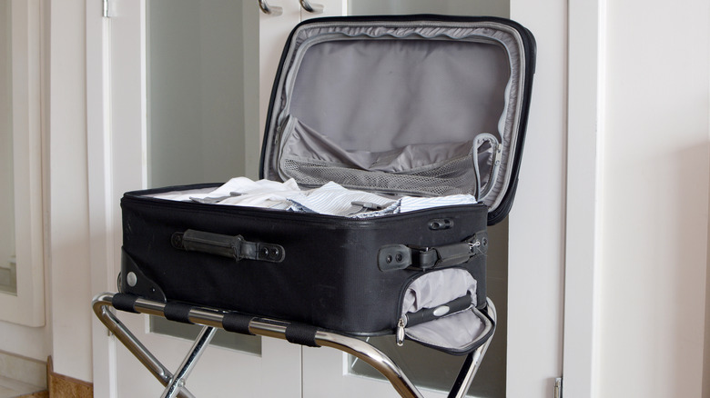 Suitcase on luggage rack in hotel room
