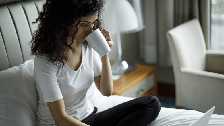 Traveler drinking coffee in a hotel room