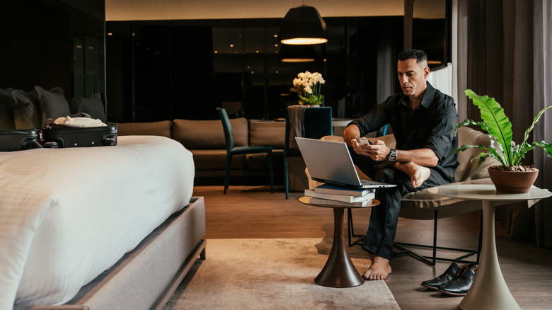 Barefoot business traveler working from hotel room