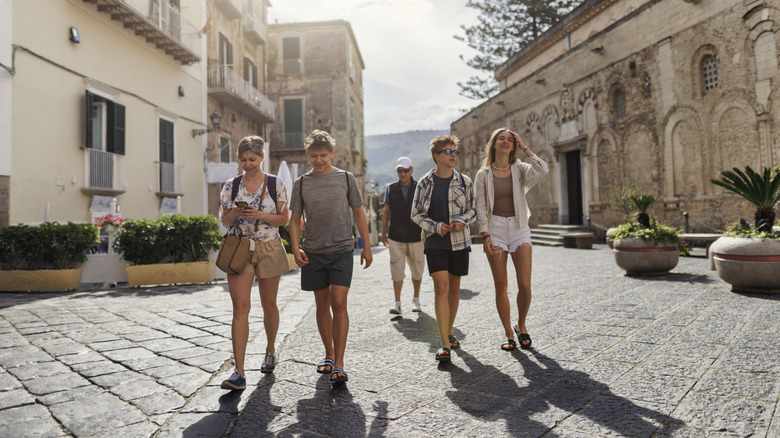 A family walking down a street in Italy wearing shorts