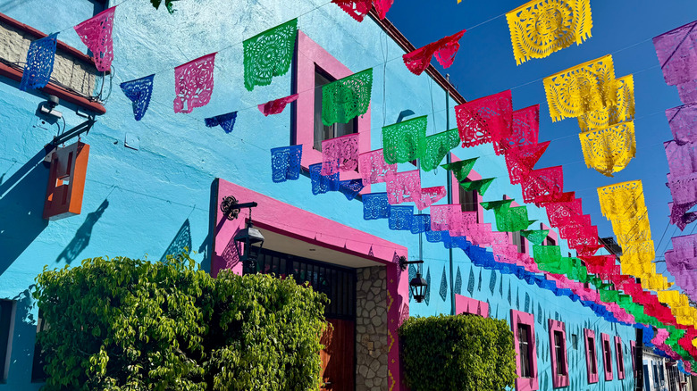 Colorful flags in front of bright buildings in Oaxaca, Mexico